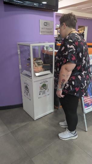 Lady looking at museum box with a barbie and typewriter